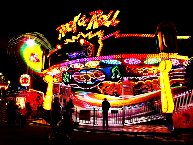 Lit up ride in motion in a fun park at night