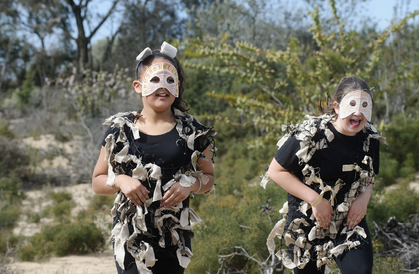 Two girls in animal costume playing in the bush