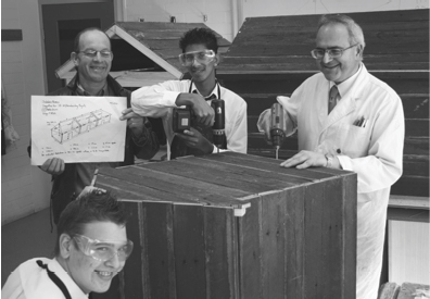 Group of men building a wooden house model