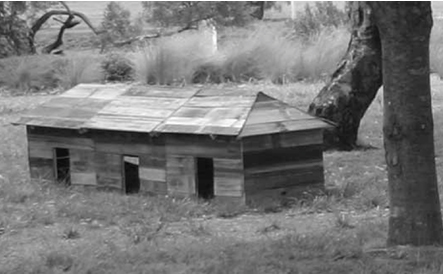 Wooden house model between trees and grass