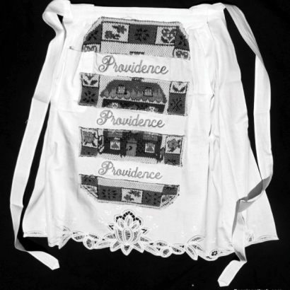 One of fourteen (14) handmade aprons celebrating Chisholm’s life